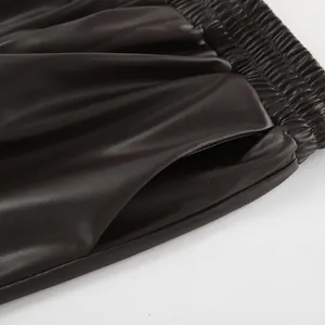 Gros plan sur la taille élastique et la poche latérale d'un pantalon en similicuir mat