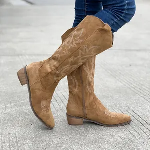 Détail de bottes mi-mollet marron vintage brodées pour femmes avec talons épais