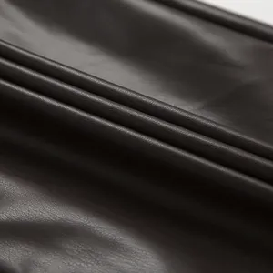 Gros plan montrant la texture et le grain du tissu en similicuir marron foncé mat haut de gamme