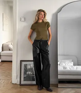 Pantalon large en similicuir noir mat à taille haute pour femme en décor intérieur