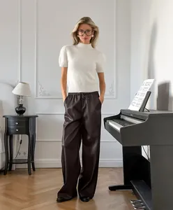 Mannequin portant un pantalon large en similicuir mat à taille haute dans une pièce