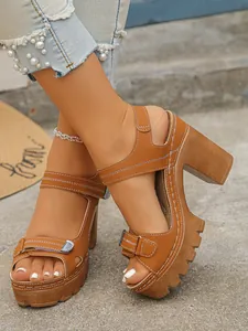 Close-up of brown platform sandals with chunky heels and white stitching detail.