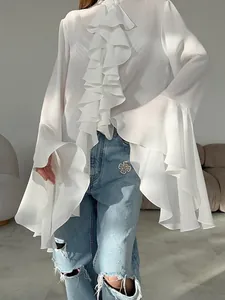 Detalle de blusa blanca de gasa con volantes escalonados y mangas acampanadas.