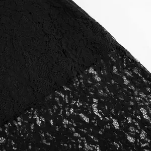 Makro-Detail von aufwendigem schwarzem Spitzenstoff an einem transparenten Maxirock