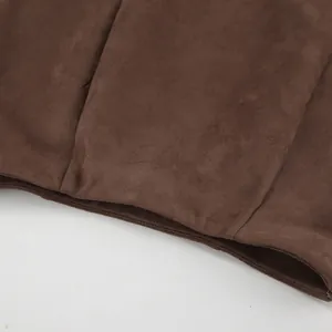 Primo piano della morbida texture scamosciata e delle cuciture di una gonna lunga marrone