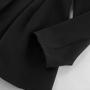 Detailaufnahme eines schwarzen Blazers mit Ärmelbündchen und gefalteter Stoffstruktur.