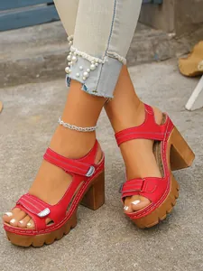 Close-up shot of stylish red platform high heel sandals with detailed white stitching