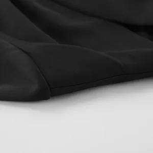 Macro view of high-quality black blazer fabric showing fine texture and neat stitching details