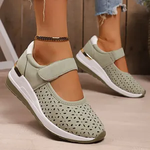 Close-up of breathable pale green hollow-out platform sneakers with velcro strap.
