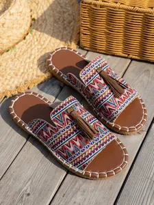 Vista detallada de las chanclas playeras boho con borla y un tejido geométrico étnico.