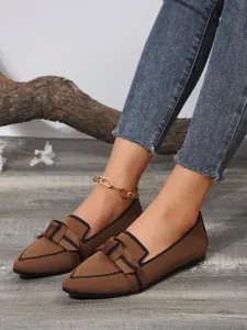 Stylish pointed-toe brown fly-knit loafers featuring elegant bow detail worn on model