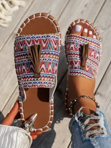 Primer plano de sandalias bohemias con estampados étnicos tejidos y borlas decorativas