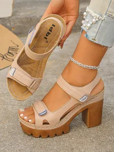 Detail view of beige platform block heel sandals with adjustable straps and metal buckles.