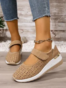 Detailed view of khaki hollow-out wedge sneakers featuring breathable laser-cut holes