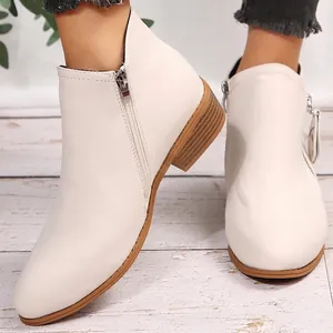 Detail showing the side zipper and chunky wood-textured heel of the white Martin boot