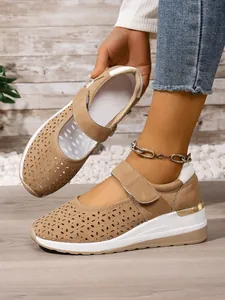 Detail view of khaki women's hollow-out wedge shoes with breathable velcro strap.