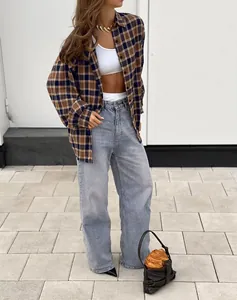 Woman styling a brown and blue plaid loose-fit shirt with wide-leg jeans and crop top