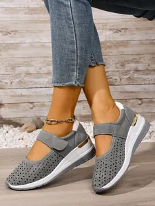 Detail view of breathable grey perforated wedge sneakers with adjustable Velcro strap detail