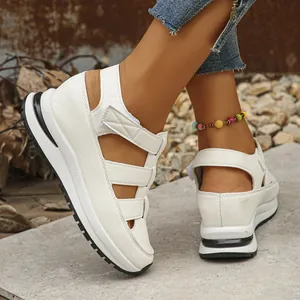 Close-up of white wedge platform sandals with hollow out design and straps