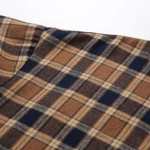 Macro detail showing the texture of a coffee plaid fabric for a casual oversized shirt