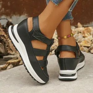 Outdoor close-up of women's black hollow wedge sandals with white platform soles