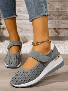 Close-up detail of grey hollow-out breathable wedge shoes with adjustable Velcro strap
