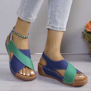Detailansicht von Keilsandalen mit grün-blauen Kreuzriemen und praktischem Klettverschluss.