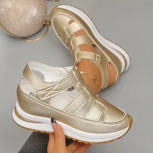 Detailed view of gold platform wedge sandals featuring hollow-out upper and velcro strap