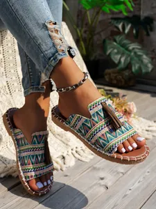 Primer plano de sandalias planas bohemias con motivos étnicos y borlas marrones