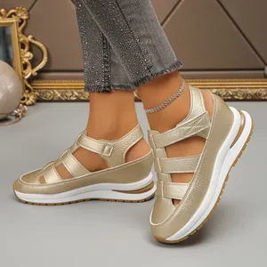 Detail shot of gold metallic hollow-out wedge sandals with thick platform soles