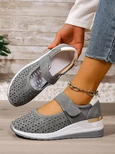 Gray laser-cut wedge sneakers with Velcro strap and thick breathable sole for women.