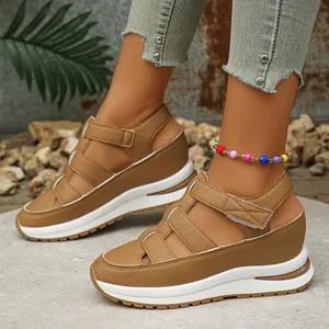 Detailed view of brown platform wedge sandals featuring hollow straps and adjustable velcro strap.