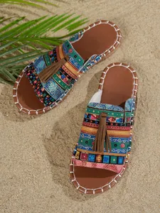 Vista detallada de sandalias de playa de estilo bohemio con patrones coloridos y borlas marrones