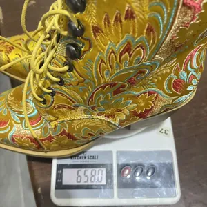 Detailansicht des Gewichts von Vintage-Stiefeletten aus besticktem Satin auf einer Waage