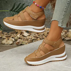 Close-up of women's breathable hollow-out wedge sandals with velcro strap in brown.