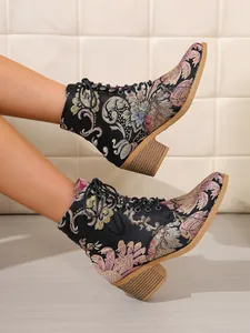 Seitenansicht schwarzer Retro-Stiefeletten mit bunter Blumenstickerei und Schnürung.