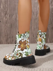 Close-up of white floral combat boots with chunky black lug sole showing embroidery details