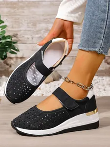 Detail of breathable hollow-out wedge sneakers with adjustable Velcro strap.