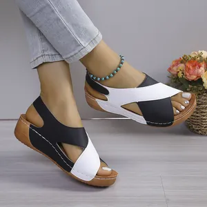 Seitenansicht von modischen Plateau-Sandalen in Schwarz-Weiß mit Keilabsatz am Model