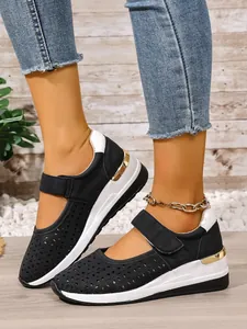 Detailed view of women's black hollow wedge sneakers featuring breathable laser-cut patterns