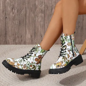 Floral printed lace-up combat boots with thick black lug soles worn on legs