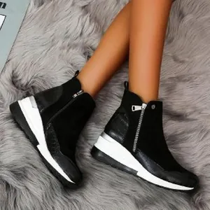 Detailed view of black wedge ankle boots with side zipper and thick white platform sole