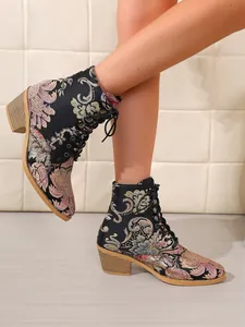 Nahaufnahme von Vintage-Stiefeletten mit Blumenstickerei und modischem Blockabsatz