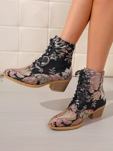 Detaillierte Ansicht von Vintage-Stiefeletten mit Blumenmuster und Schnürung am Model.