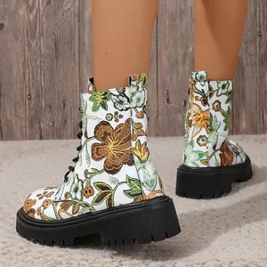 Close-up of women's floral printed combat boots with black platform soles on a model