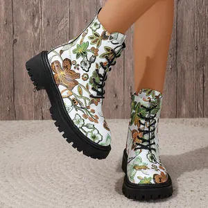 Detailed view of white floral print ankle boots featuring thick black platform soles.