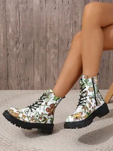 Detailed view of white floral print combat boots with black laces and side zipper