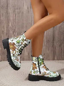 Side detail of white floral embroidered ankle boots with black lace-up and lug soles