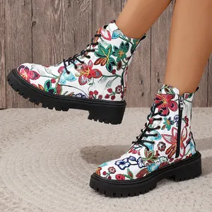 Close-up detail of white Martin boots featuring vibrant floral embroidery and lug soles.