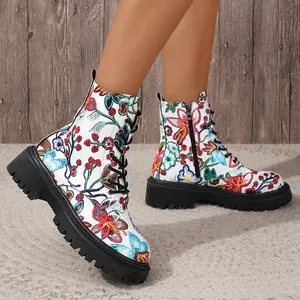 Detail view showing the vibrant floral print pattern on white lace-up combat boots.